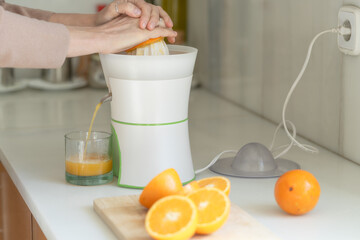 woman making orange juice in kitchen