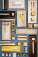 Flat lay of various wood and plywood pieces on concrete texture. Carpentry background.