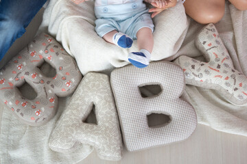 Peaceful Infant in Blue Overalls Surrounded by Decorative Letter Blocks