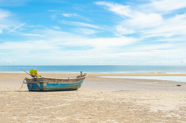 Fototapeta premium Lonely boat on a tranquil beach under blue sky