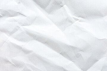 Crumpled white paper texture with folds and creases for background or design elements.