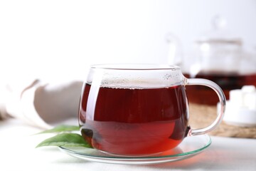 Refreshing black tea in cup on light table, closeup