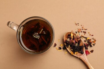 Fototapeta premium Aromatic tea and dried leaves on brown background, flat lay