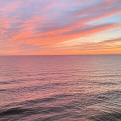 Obraz premium Peaceful Pink and Orange Sunset Over Calm Ocean Waters