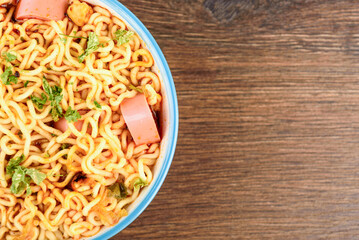 Close-up of part of a bowl with cooked instant noodles with space for text.