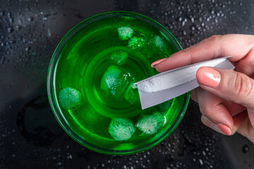 Pouring GHB into a colorful drink glass