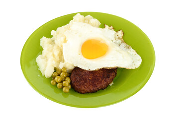 Appetizer of cutlet with fried egg, mashed potatoes and green peas, on a plate.