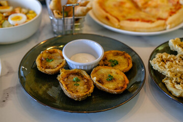 baked pane pasta with mayonnaise sauce served on a black plate