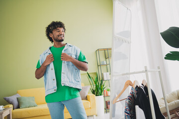 Portrait of nice young man fitting vest look mirror wear t-shirt modern green interior flat indoors