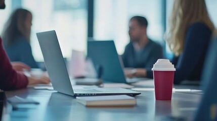  A marketing team reviews campaign data in a modern conference room, analyzing insights with a laptop open for strategy planning.