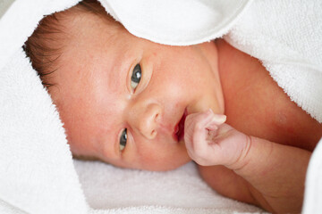 baby is hiding under the white blanket