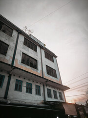The architecture of an old building with turquoise wooden windows and faded, mossy walls