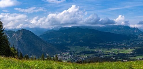 Panorama view of Schoenau town on the lake side of Koenigssee lake in Berchtesgadener Land from middle station of mountain Jenner on a sunny summer day with blue sky and cloud, Bavaria, Germany