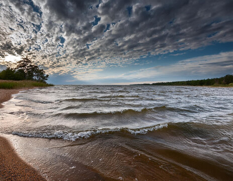 dramatic clouds over tranquil lake shoreline with rolling waves
