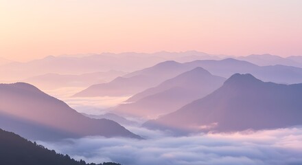 Ethereal mountain range layers are shrouded in soft clouds, painted in pastel pinks and purples at sunrise. Peaceful, calming and majestic landscape scenery.
