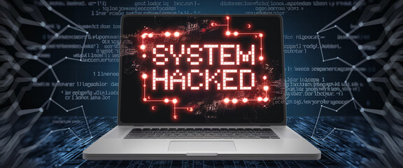 Close-up of a laptop with a red "SYSTEM HACKED" notification on the screen, showcasing a digital security breach in a tech environment, symbolizing cyber threats and hacking incidents.