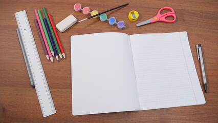 Empty school notebook with school supplies nearby. Top view