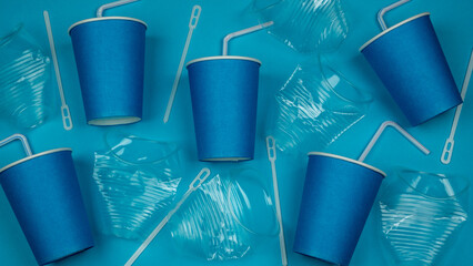 Blue background with plastic and paper cups and straws