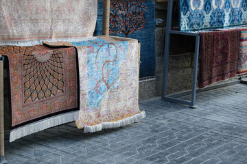 traditional Uzbek carpets hang in a market in Bukhara