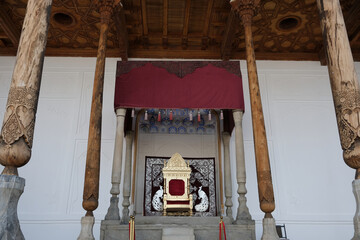 elegant throne under a decorative canopy among tall carved wooden columns, Bukhara