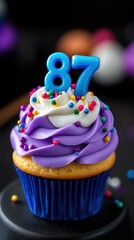 "87" birthday. Colored cupcake with whipped cream, sprinkles. candles number "87"