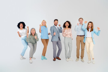 Fototapeta premium Diverse group of cheerful business professionals celebrating teamwork on a light background
