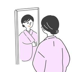 鏡の前でピンク色の着物の着付けをする黒髪女性