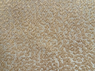 Close up of decorative gold fabric in random round ripples or clouds pattern texture. Bronze gold fabric seamless background texture.