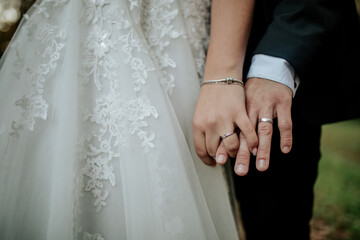 Bride and Groom Holding Hands with Wedding Rings