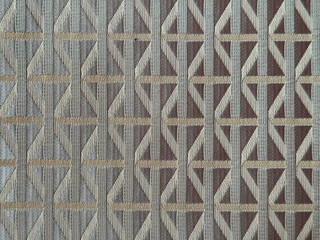 Close up of dark brown color fabric in random geometric diamond and lines pattern. Dark brown and silver grey color fabric in abstract modern geometrical texture. Seamless fabric background texture.