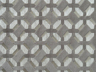 Close up of grey fabric in random geometric hexagon, diamond, and checkered pattern. Dark grey fabric in abstract modern geometrical texture. Seamless fabric background texture.