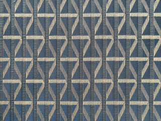 Close up of dark blue color fabric in random geometric diamond and lines pattern. Dark blue and silver grey color fabric in abstract modern geometrical texture. Seamless fabric background texture.