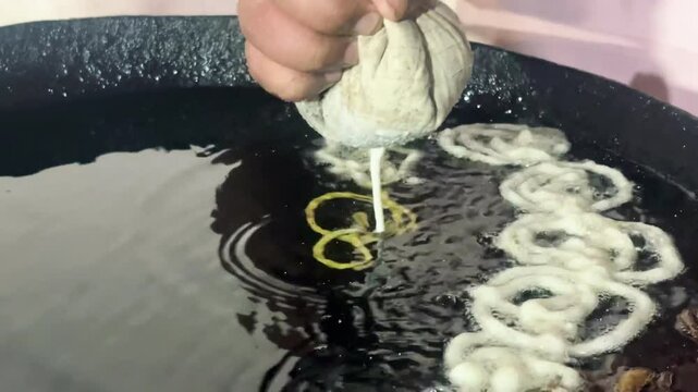 hands making funnel cakes, frying in Embroidery on shop Indian famous sweets
