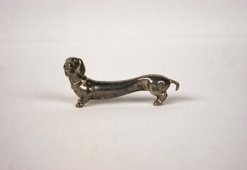 Silver Dachshund figurine on a white table
