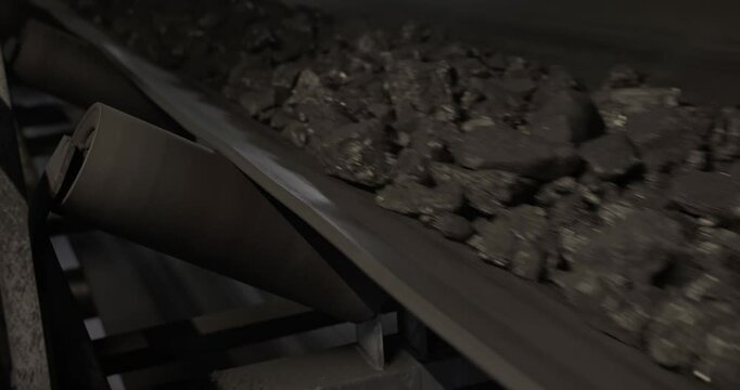 Conveyor belt with coal shooting in slow motion. Close-up of coal on conveyor belt. Conveyor belt with ore. Machine for loading coal. Tape conveyor used to load Anthracite mining coal mine factory.