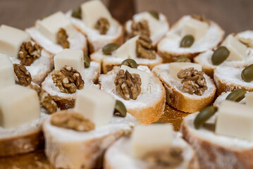 A close up of canapés topped with cheese walnuts and olives ready for a delicious and elegant appetizer