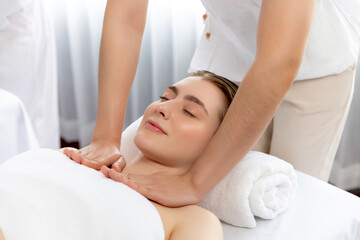 Caucasian woman customer enjoying relaxing anti-stress spa massage and pampering with beauty skin recreation leisure in day light ambient salon spa at luxury resort or hotel. Quiescent