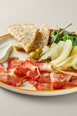 Gourmet Charcuterie Parmesan, Parma Ham, Olives, Cream Cheese, and Toast on Elegant Plate