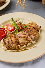 Grilled Chicken Thigh Skewers with Vegetables and Red Sauce on Rustic Plate