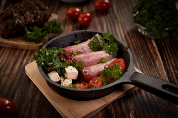 close-up of a frying pan with a finished dish. Pieces of meat and chopped vegetables are arranged in an appetizing frying pan.