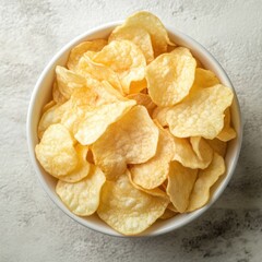 Crispy golden potato chips in a white bowl on a textured gray background overhead shot with natural light food photography