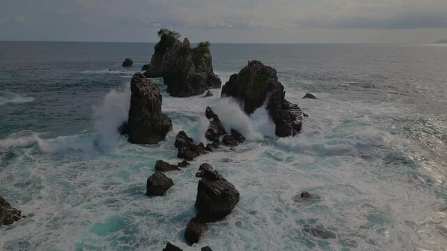 Drone view of Sharks Teeth Beach with its jagged rock formations and crashing waves at sunset