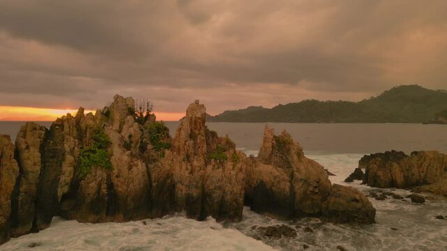 aerial view of Sharks Teeth Beach with its jagged rock formations and crashing waves at sunset