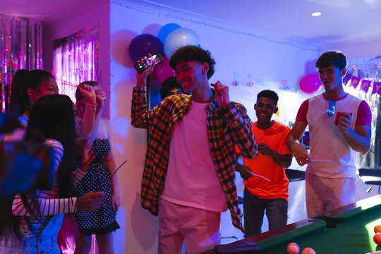 Teen diverse friends dancing joyfully at home party, celebrating with friends and music - Powered by Adobe
