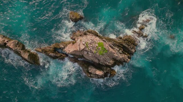 Aerial view of jagged rock formations and crashing waves on Sharks Teeth Beach of Indonesia