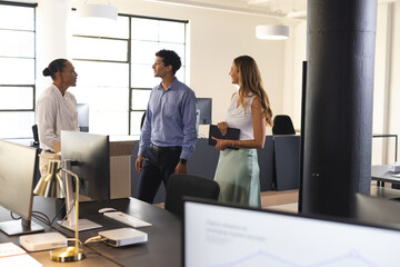 Business diverse professionals discussing project in modern office, engaging in conversation