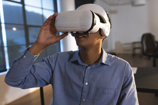 Man using VR headset in modern office, exploring virtual reality technology