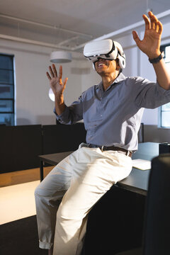 Man using VR headset in office, engaging with virtual environment enthusiastically