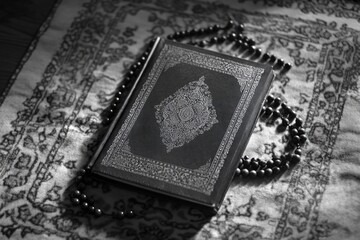 Naklejka premium An open Quran on a prayer mat, symbolizing Islamic faith and spiritual practice.