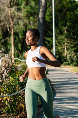 Young black woman running in a park wearing sportswear